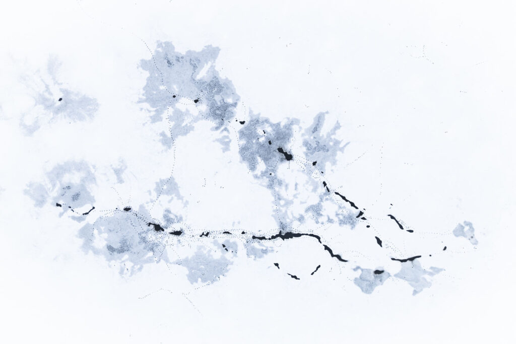 Abstract ice patterns on frozen reservoir resembling map-like structures in snow